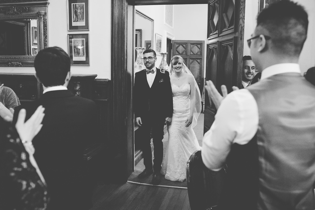 bride and groom enter the room for wedding breakfast at Wroxall Abbey