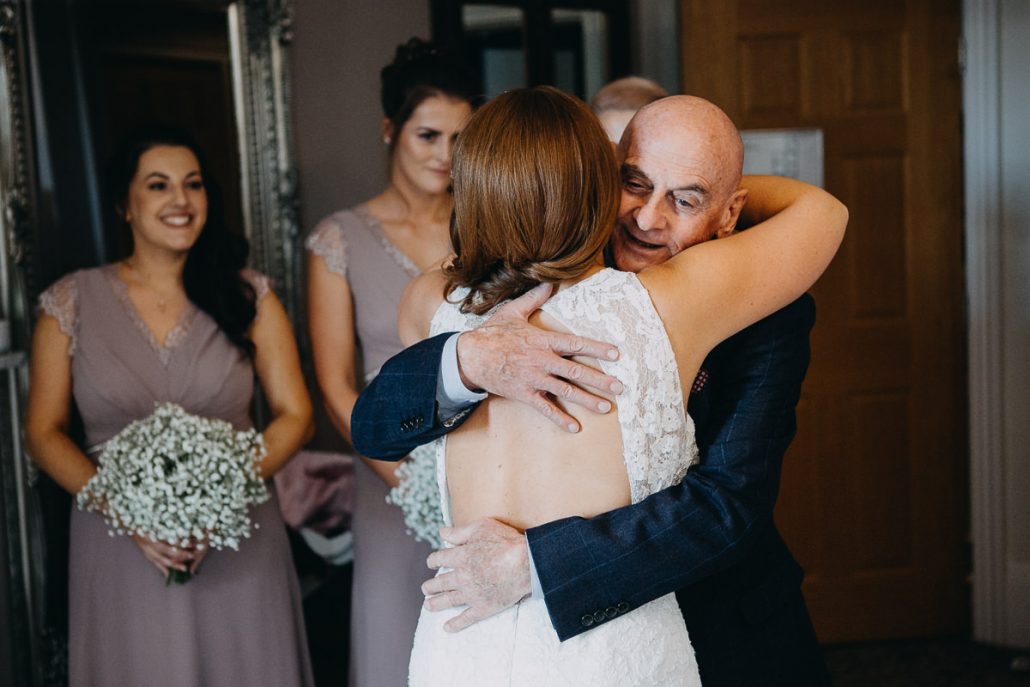 father of the bride hugs the bride