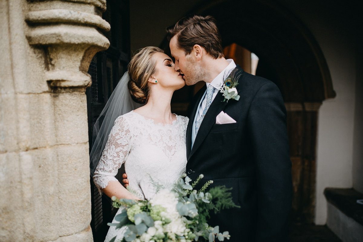 kiss outside of the church bride and groom